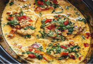 Crockpot Tuscan garlic chicken thighs in cream sauce with spinach and sun-dried tomatoes